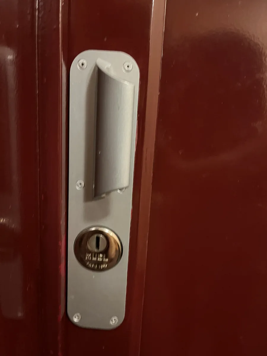 Poignée blindée MUEL sur porte acajou par AMG Serrurerie