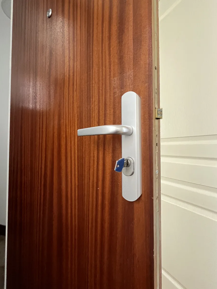 Poignée blindée posée sur porte acajou par AMG Serrurerie